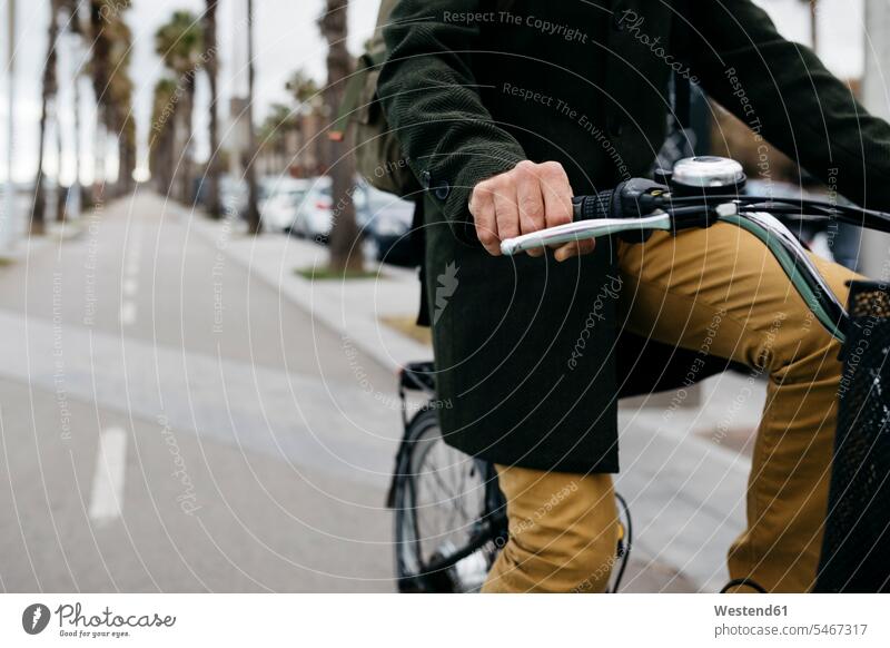 Close-up of man riding e-bike on a promenade males E-Bike Electric bicycle Electric Bike promenades riding bicycle riding bike bike riding cycling bicycling