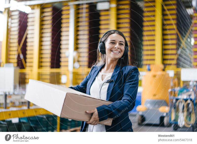 Young woman working at parcel service, carrying parcel in warehouse packet packets parcels messenger service courier service employee employess company firm