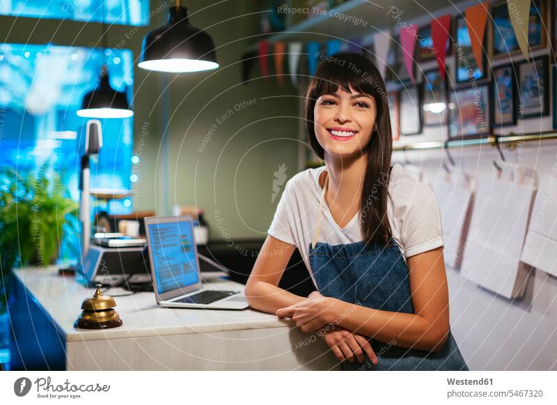 Portrait of happy woman with laptop in a store happiness Laptop Computers laptops notebook portrait portraits shop females women computer computers retail trade