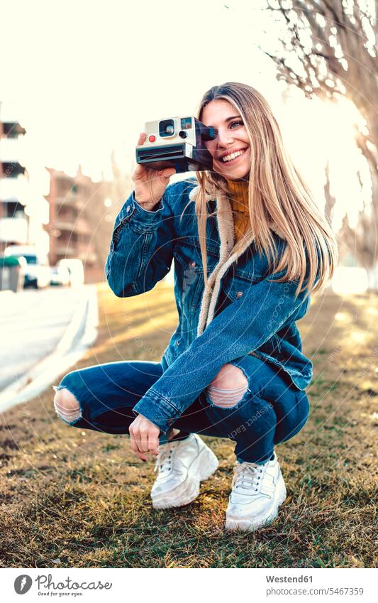 Portrait of smiling young woman using instant camera polaroid camera females women portrait portraits use smile Adults grown-ups grownups adult people persons
