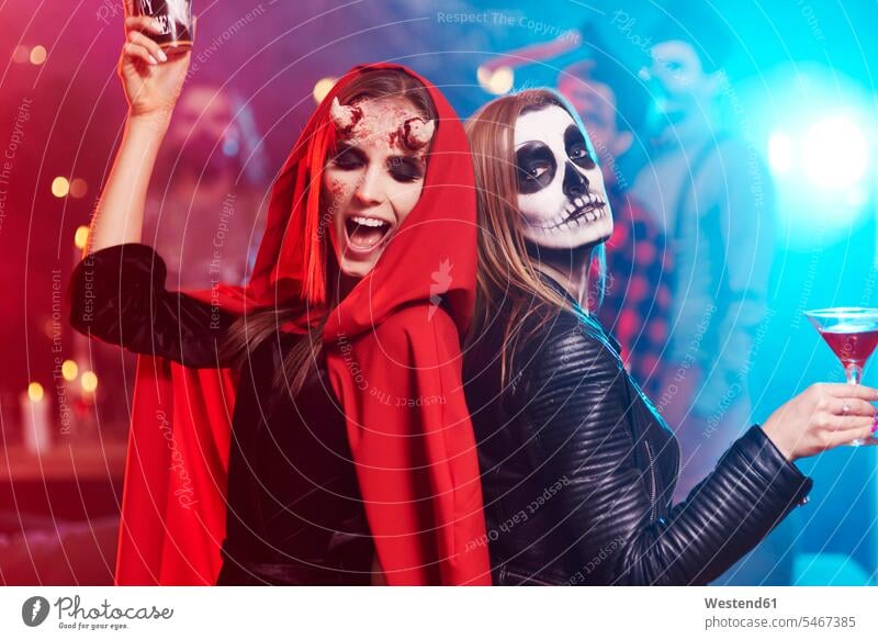 Women in creepy costumes dancing at Halloween party friends All Hallows' Eve female friends hooded celebrating celebrate partying dance Party Parties friendship