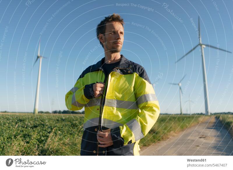 Portrait of an engineer on field path at a wind farm country lane field road portrait portraits engineers wind park engineering engineering science technology