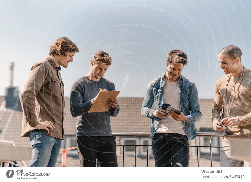 Young entrepreneurs brainstorming on a roof terrace write Writing - Activity stand Solution Ideas creative location shot location shots outdoor outdoor shot