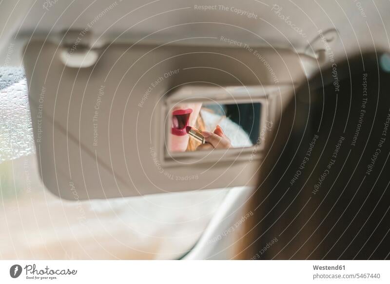 Woman mirrored in rear view mirror applying red lipstick in car Lipstick Lipsticks rear-view mirror Rear Mirror rearview mirror driving mirror automobile Auto