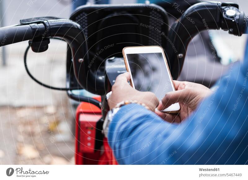 Hands of man using smart phone for renting bicycle at parking station color image colour image Spain leisure activity leisure activities free time leisure time