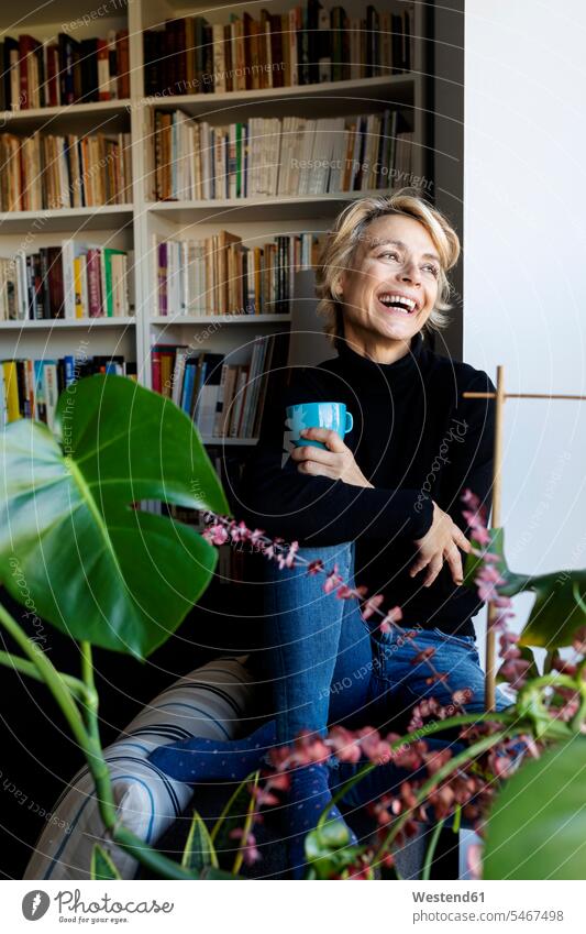 Happy mature woman drinking coffee and relaxing at home human human being human beings humans person persons celibate celibates singles solitary people