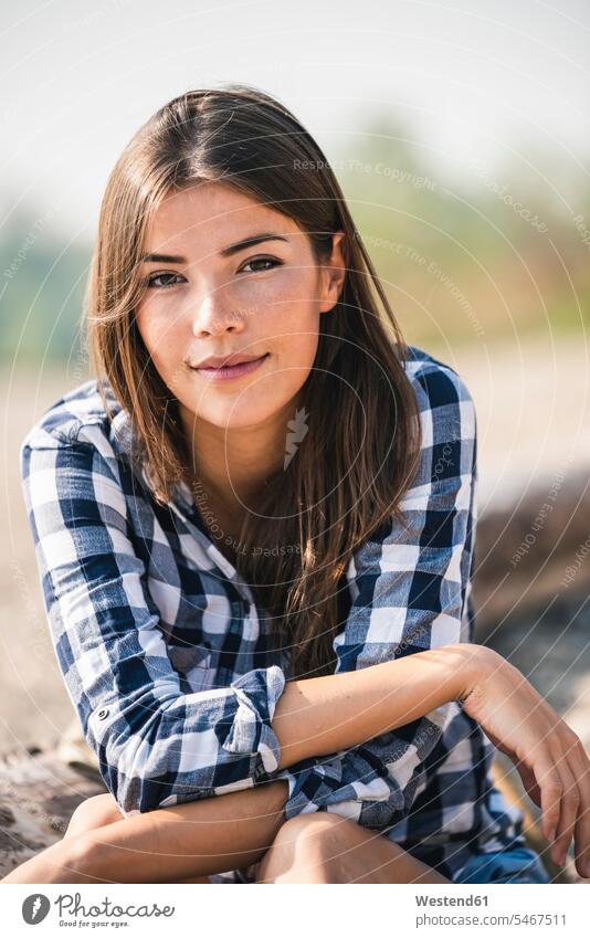 Portrait of smiling young woman sitting outdoors smile Seated females women portrait portraits Adults grown-ups grownups adult people persons human being humans