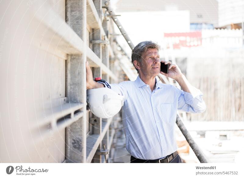 Man on cell phone on construction site Building Site sites Building Sites construction sites on the phone call telephoning On The Telephone calling mobile phone