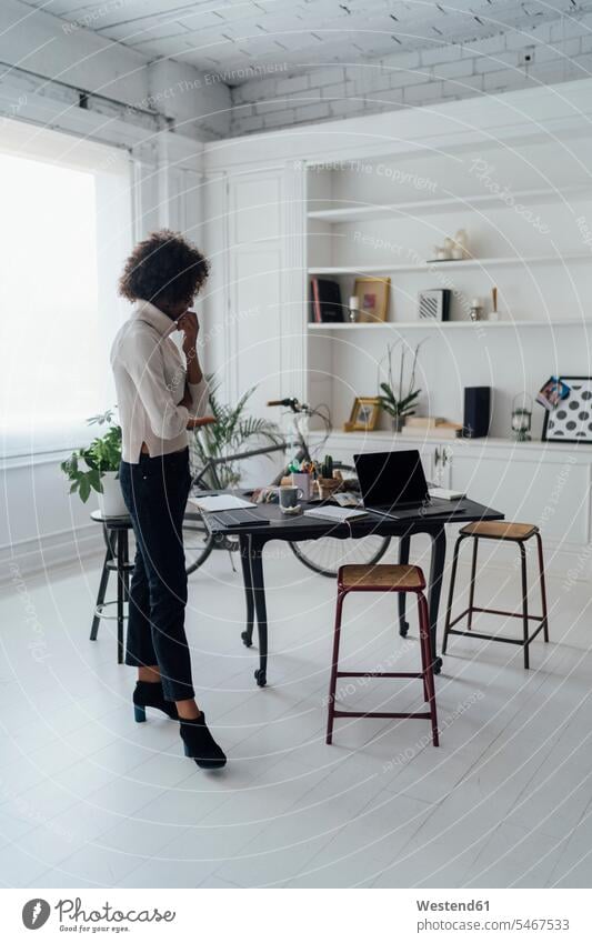 Freelancer standing in her home office, thinking Spain working from home working at home Work From Home telecommuting teleworking home business flat flats