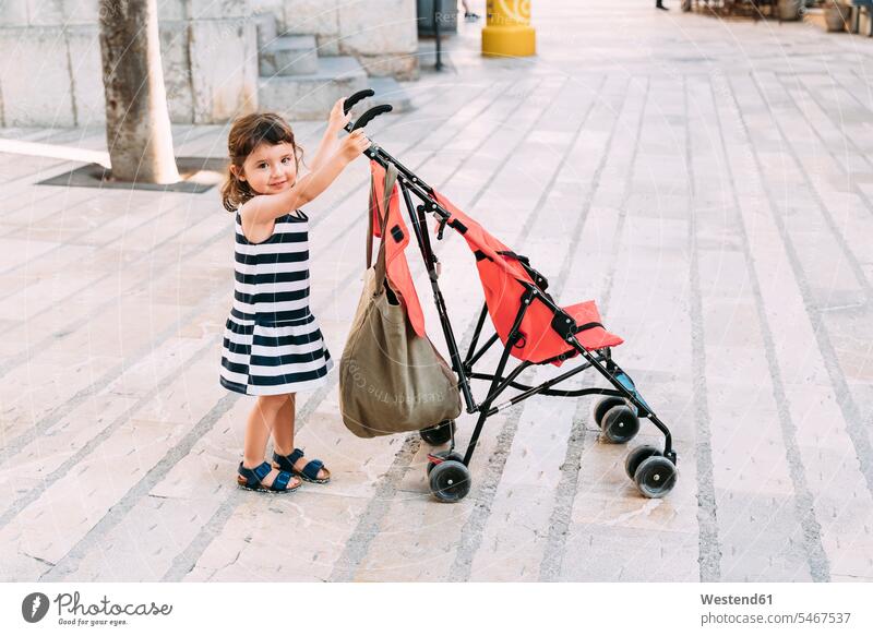 Portrait of smiling little girl pushing her stroller human human being human beings humans person persons caucasian appearance caucasian ethnicity european 1