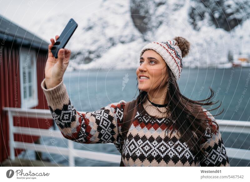 Tourist taking a selfie at the coast, Lofoten, Norway touristic tourists telecommunication phones telephone telephones cell phone cell phones Cellphone mobile