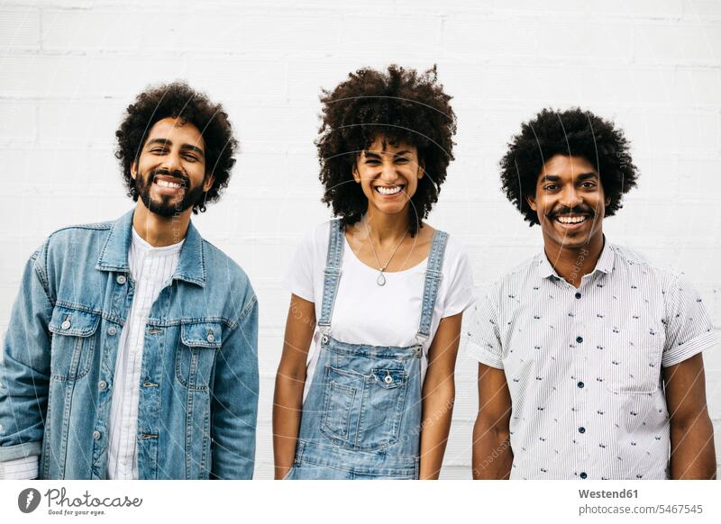 Group picture of three laughing friends in front of white wall Laughter group picture Group Portrait group foto walls friendship positive Emotion Feeling