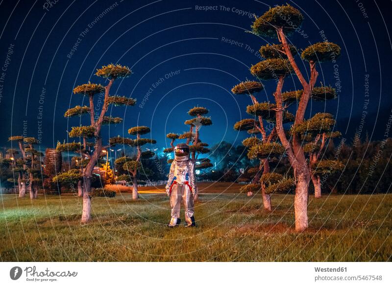 Spaceman standing in a park at night by night nite night photography spaceman spacemen astronaut astronauts parks astronautics space travel alien aliens silver