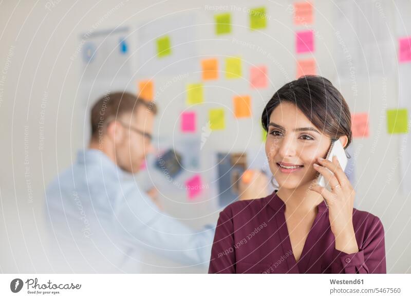 Businesswoman in office on the phone businesswoman businesswomen business woman business women mobile phone mobiles mobile phones Cellphone cell phone