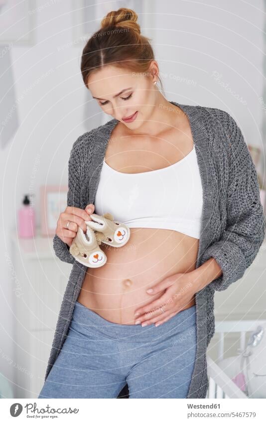 Pregnant woman with baby booties females women home at home portrait portraits smiling smile pregnant Pregnant Woman baby shoes Baby Shoe Adults grown-ups