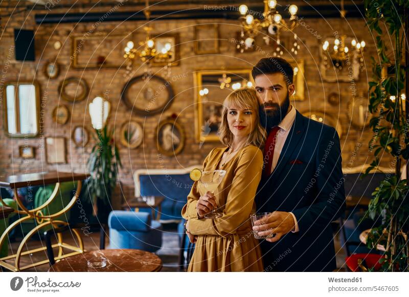 Portrait of elegant couple with drinks in a bar bars Drink Drinks twosomes partnership couples portrait portraits chic elegance stylishly classy Alcohol