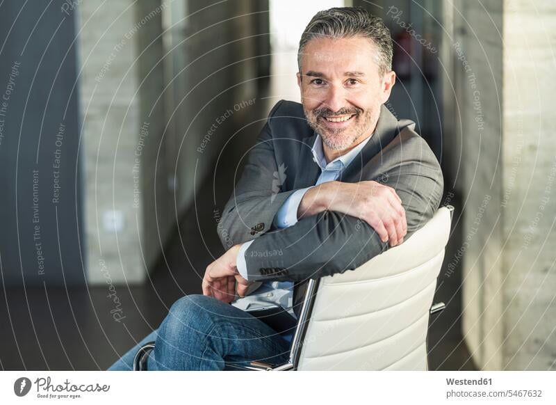 Portrait of a smiling mature businessman sitting on chair in office Occupation Work job jobs profession professional occupation business life business world