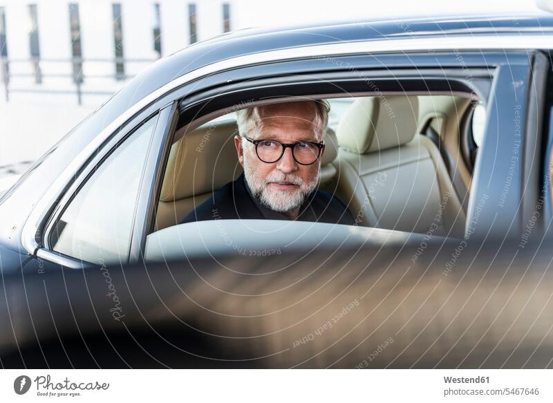 Mature businessman sitting on backseat in car, looking out of window Looking Through Window Looking Through A Window looking through glass Businessman