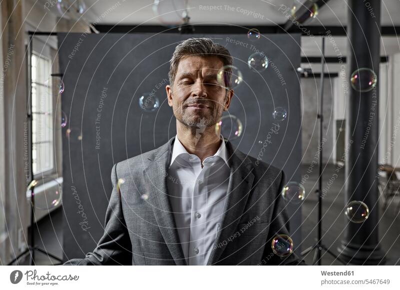 Portrait of mature businessman with bubbles in front of black backdrop in loft lofts Backdrop portrait portraits Businessman Business man Businessmen
