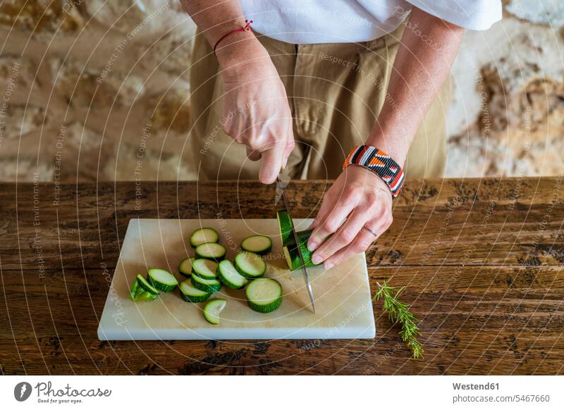 Female dietitian cutting cucumber on marble board at table color image colour image Spain day daylight shot daylight shots day shots daytime