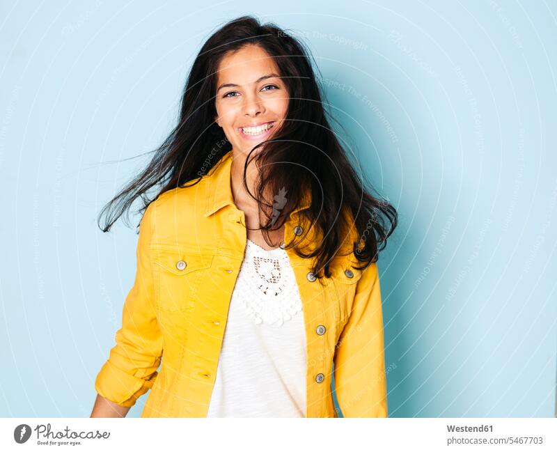 Portrait of young woman with black hair wearing yellow denim jacket, light blue background caucasian caucasian ethnicity caucasian appearance european content
