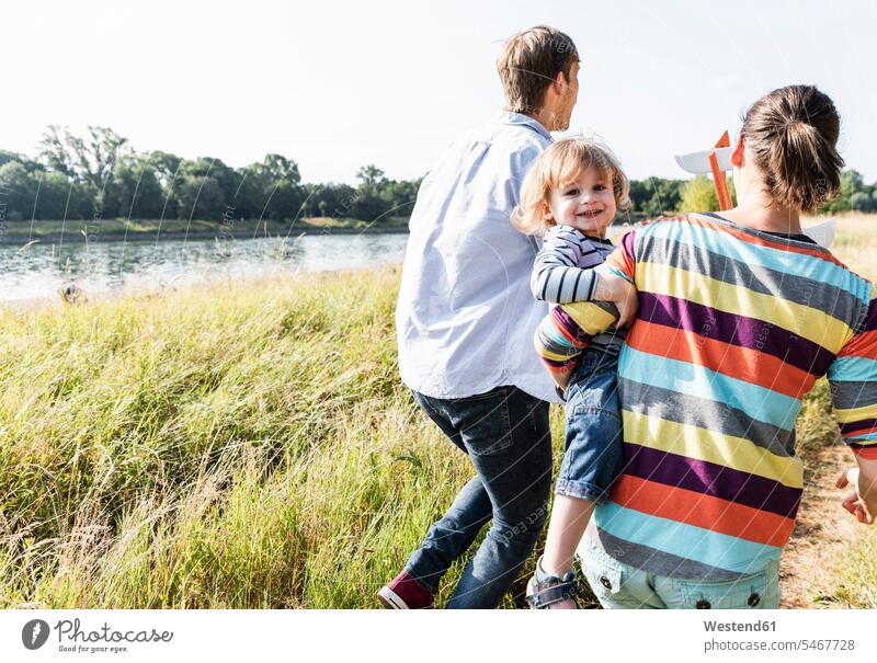 Happy family walking at the riverside on a beautiful summer day Meadow Meadows summer time summery summertime riverbank happiness happy going Plant Plants