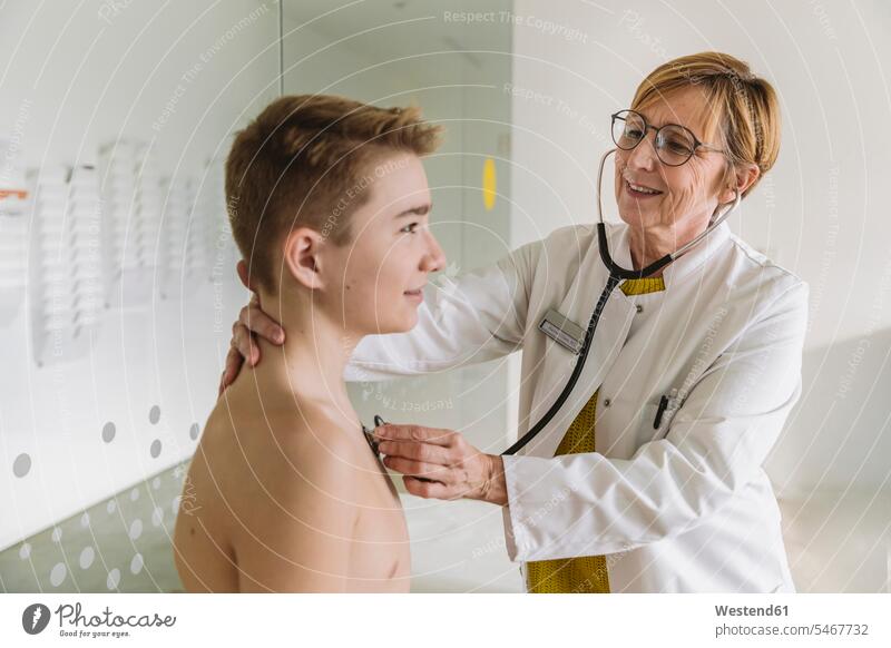Doctor examining teenage boy with a stethoscope human human being human beings humans person persons caucasian appearance caucasian ethnicity european 2
