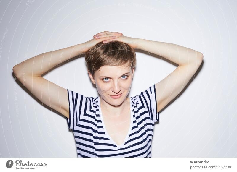 Portrait of blond woman, short hair, hands on head cropped hair shorthaired short-haired blond hair blonde hair females women looking at camera