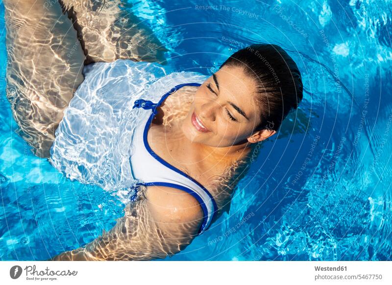 Portrait of plump young woman relaxing in swimming pool - a