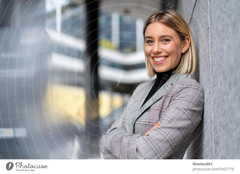 Portrait of confident young businesswoman leaning against a wall human human being human beings humans person persons caucasian appearance caucasian ethnicity
