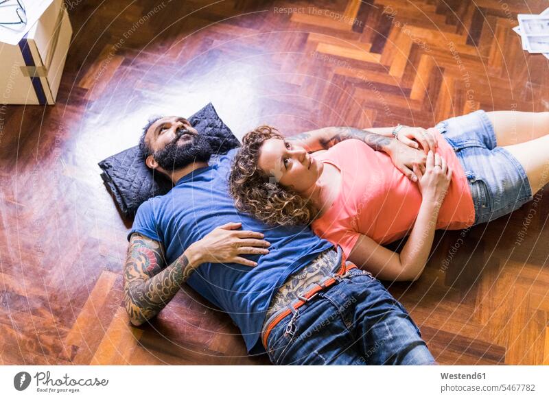 Daydreaming couple lying on the floor of new home Floor Floors laying down lie lying down at home twosomes partnership couples floors people persons human being