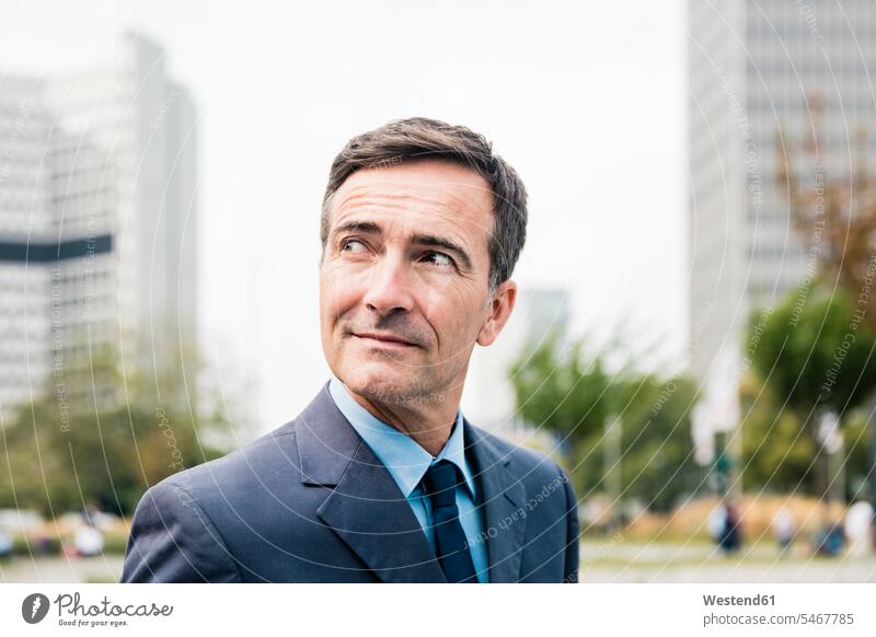 Portrait of confident businessman in the city looking sideways confidence sideways glance Sideway Glance side glance portrait portraits town cities towns