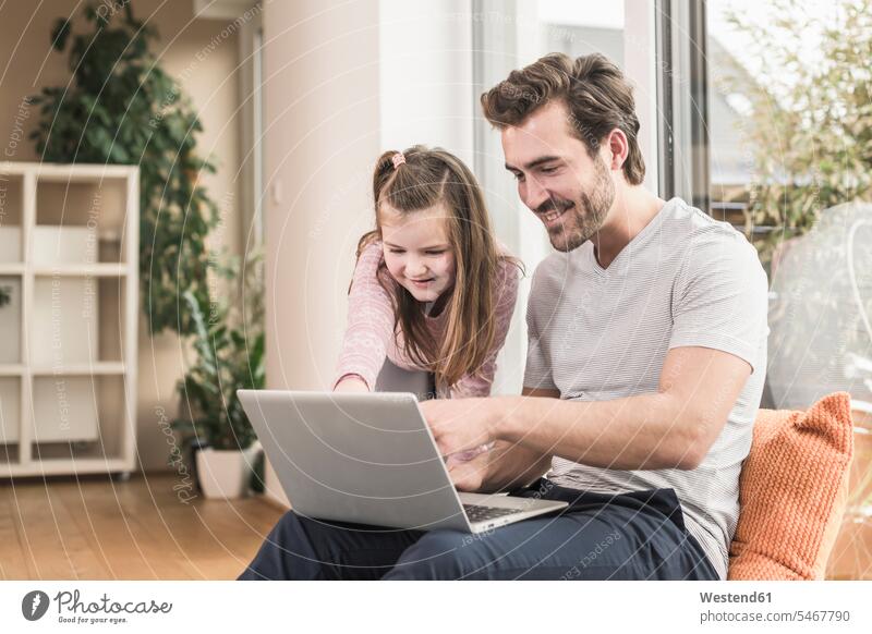 Young man and little girl surfing the net together Surfing the Net shelf Shelve rack racks shelves living room living rooms livingroom accessibility accessible