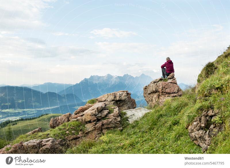 Austria, Tyrol, Fieberbrunn, Wildseeloder, woman sitting on stone with view on mountainscape Seated View Vista Look-Out outlook mountainscapes mountain scenery