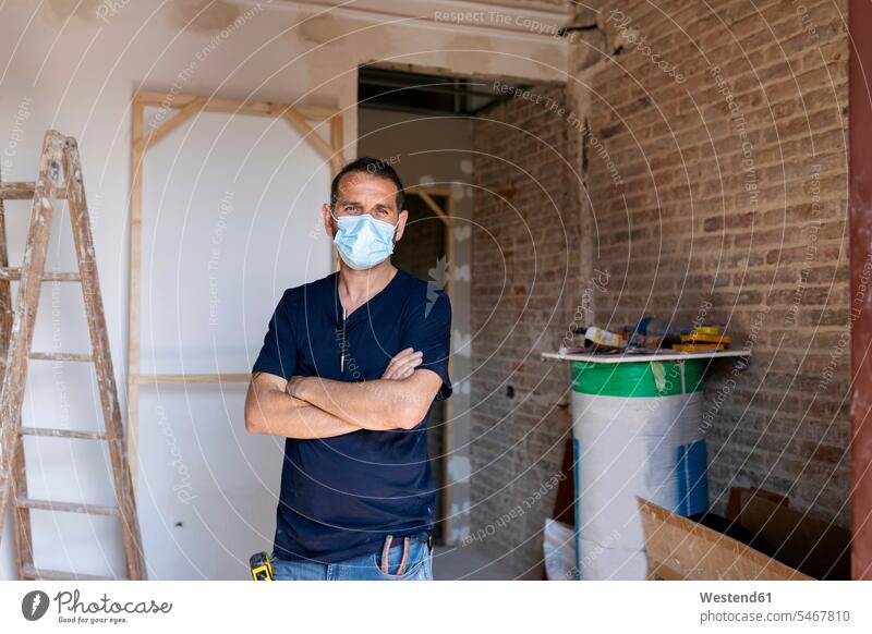 Portrait of a man wearing protective face mask in a house under construction Occupation Work job jobs profession professional occupation blue collar
