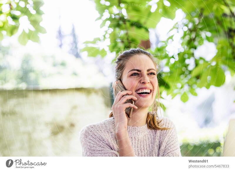 Portrait of laughing woman on the phone outdoors call telephoning On The Telephone calling Smartphone iPhone Smartphones portrait portraits females women