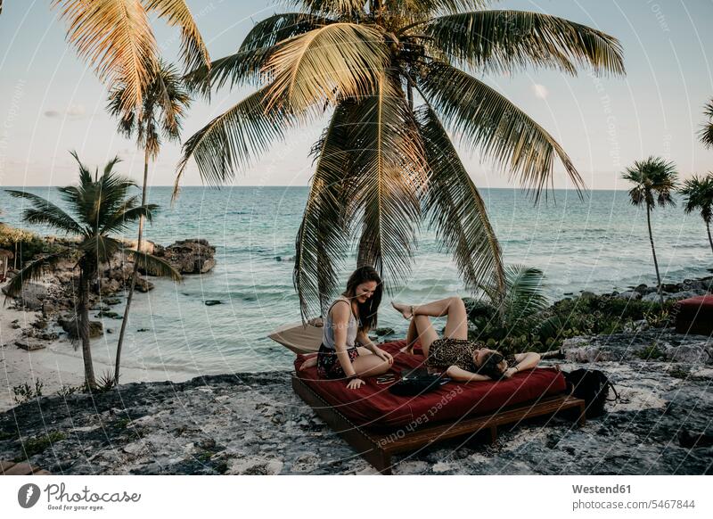 Mexico, Quintana Roo, Tulum, two happy young women relaxing on the beach sea ocean female tourist Mattress Mattresses stony recreation Recreational togetherness