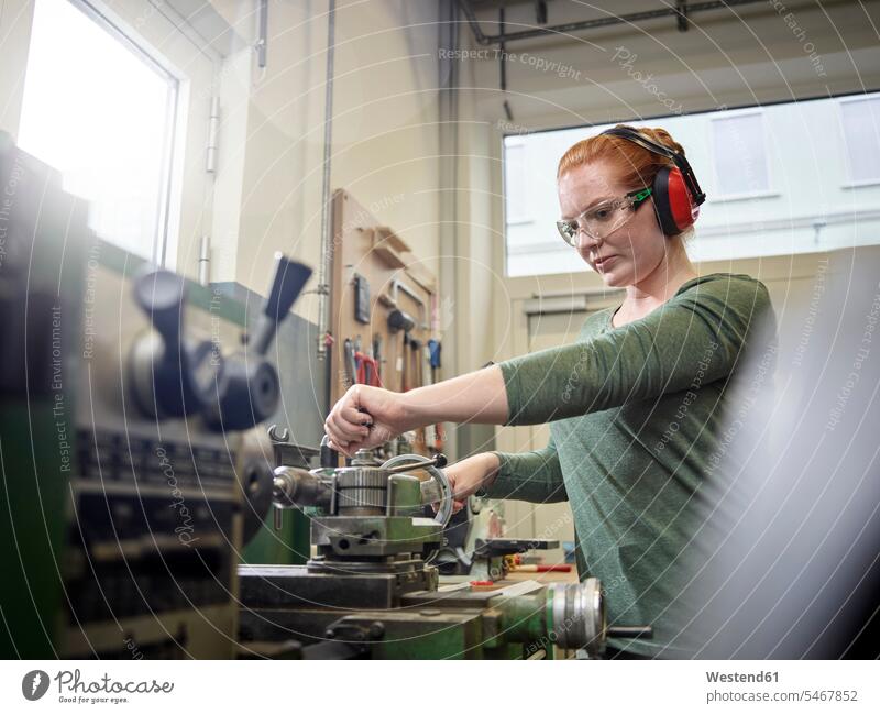Woman working at a lathe Occupation Work job jobs profession professional occupation blue collar blue collar worker blue-collar worker workers engineering