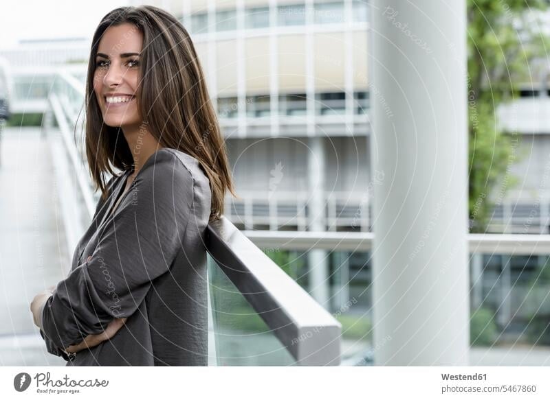 Smiling young businesswoman looking at distance businesswomen business woman business women smiling smile portrait portraits business people businesspeople