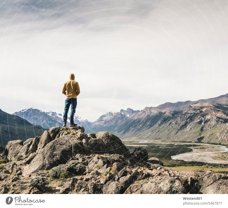 Mature man wearing hood looking at mountains against sky while standing on rock, Patagonia, Argentina Patagonia - Argentina South America Patagonian Andes