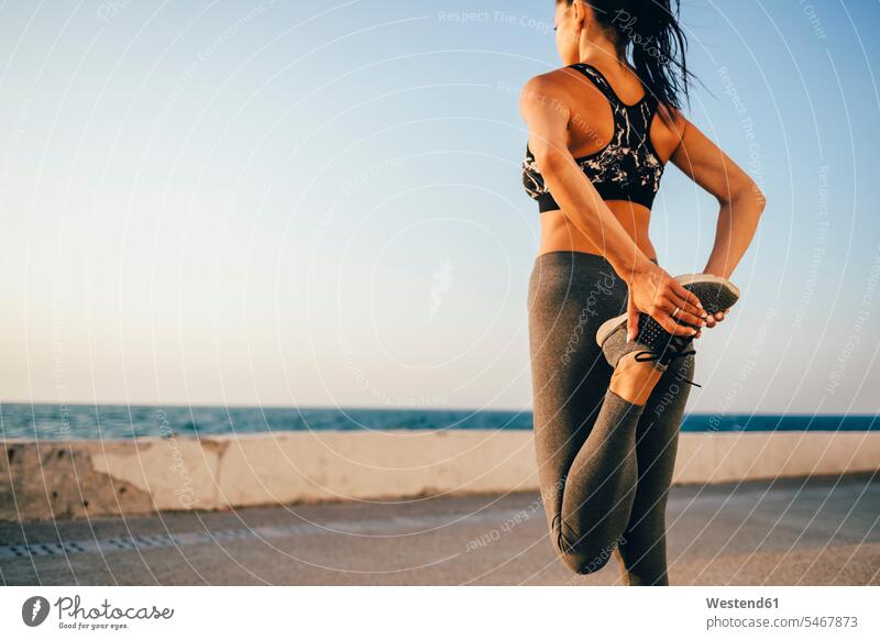 Young sportswoman stretching her leg on a pier human human being human beings humans person persons 1 one person only only one person adult grown-up grown-ups