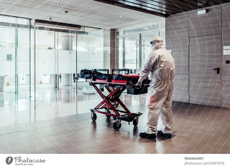 Ambulance, doctor wearing protective suit pushing empty stretcher emptiness healthy emergencies State Of Emergency protecting safe Safety secure healthcare
