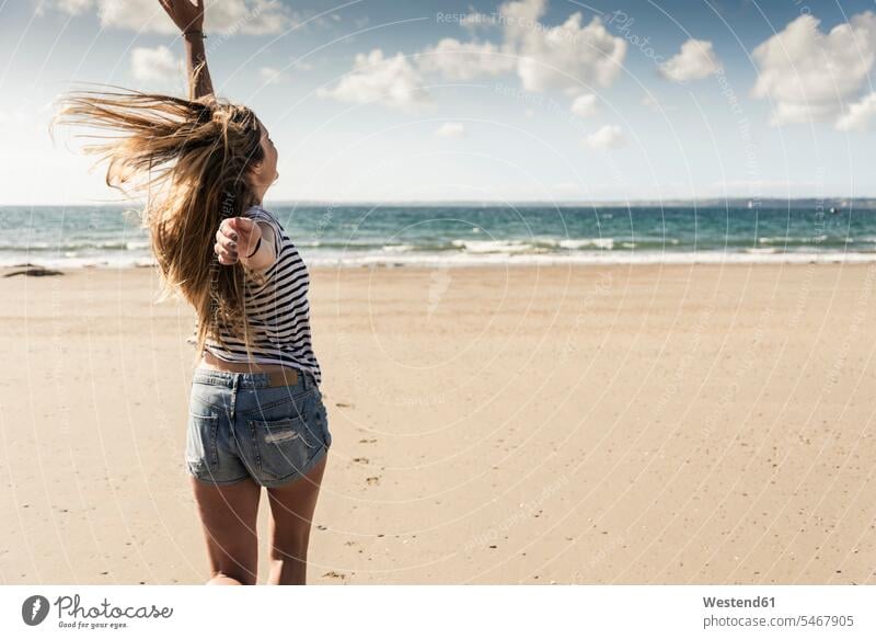 Happy young woman dancing on the beach turning dance spinning beaches young women females Adults grown-ups grownups adult people persons human being humans