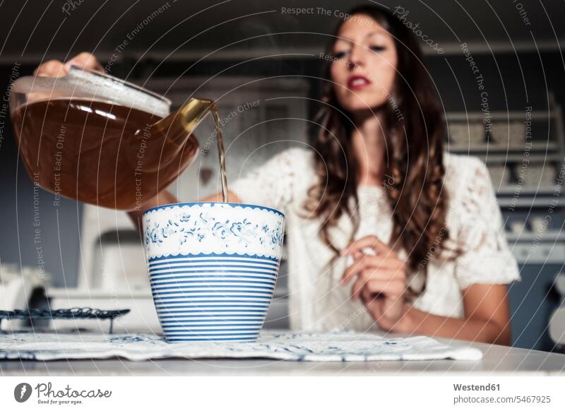 Young woman pouring tea into cup Table Cloth Table Cloths Table-Cloth Tablecloths colour colours White Colors at home Attractiveness beautiful good-looking