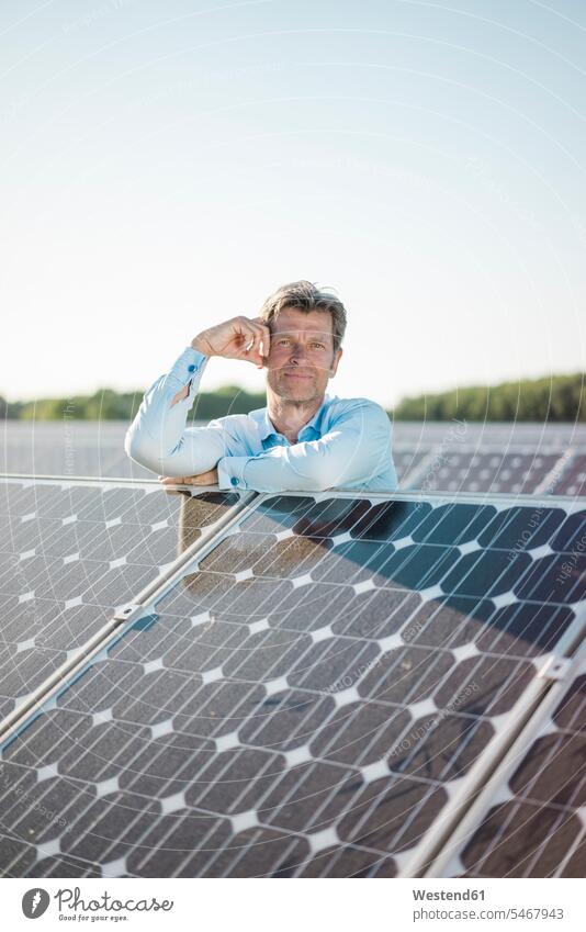 Mature man standing in solar plant technology technologies Technological alternative energy ecology men males Solar Power Station smiling smile Green Energy