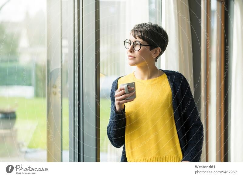 Portrait of woman with cup of coffee looking out of window Coffee Coffee Cup Coffee Cups portrait portraits windows females women view seeing viewing Drink