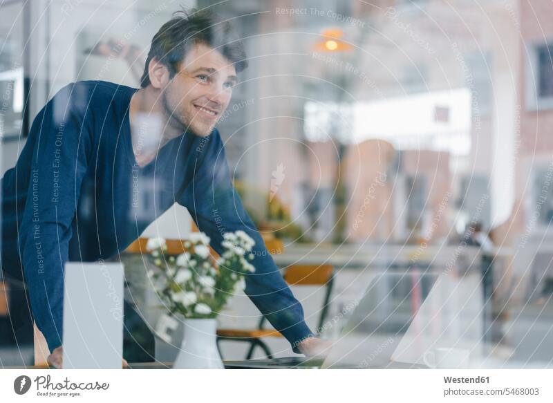 Smiling man in a cafe looking out of window men males windows smiling smile view seeing viewing Adults grown-ups grownups adult people persons human being