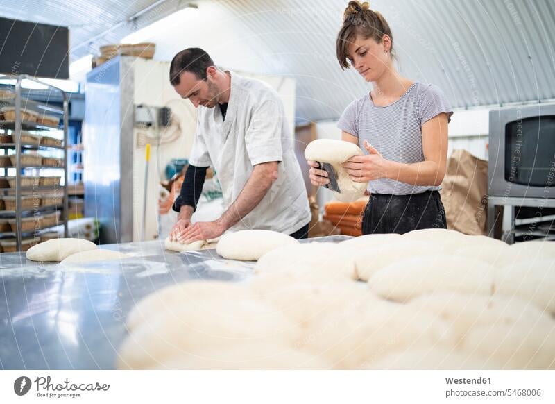 Man and woman preparing loaves of bread in bakery colleague Occupation Work job jobs profession professional occupation crafts hand work handcraft handicraft