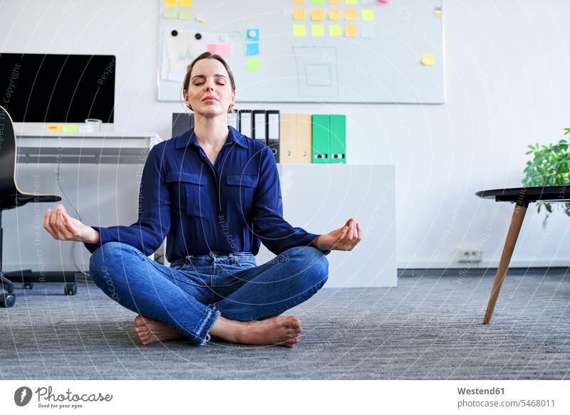 Creative businesswoman meditating in office color image colour image indoors indoor shot indoor shots interior interior view Interiors businesswomen