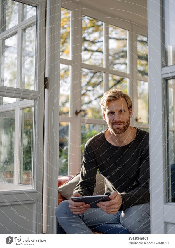 Portrait of man using tablet in sunroom at home human human being human beings humans person persons caucasian appearance caucasian ethnicity european 1